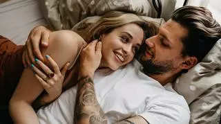 Kobieta i mężczyzna z tatuażami leżą w łóżku