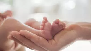 Stopy noworodkach w dłoni dorosłego człowieka