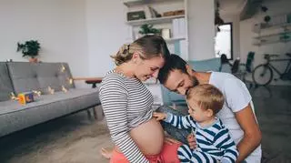 Kobieta w ciąży z mężem i dzieckiem 
