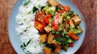 Tofu z warzywami i ryżem na talerzu.