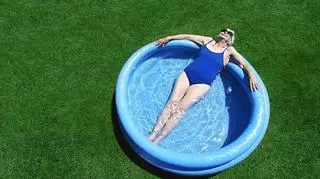 Starsza kobieta w kostiumie kąpielowym w basenie ogrodowym. Basen dmuchany