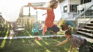 Chłopiec i dziewczynka bawią się w ogrodzie