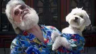 starszy siwy mężczyzna i biały pies w koszulach hawajskich