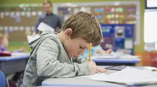 chłopiec, który pisze coś w zeszycie 