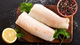 Deska, na której leżą dwa filety z dorsza 