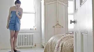 Kobieta w ręczniku stoi na wadze 