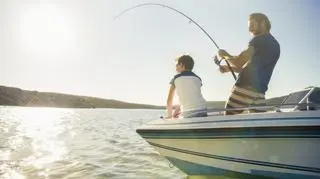 Ojciec z synem łowią ryby na łódce