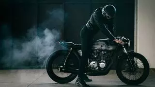 Mężczyzna na motorze na czarnym tle. Dobrze widać opony.