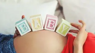 Napis BABY na brzuchu ciężarnej kobiety