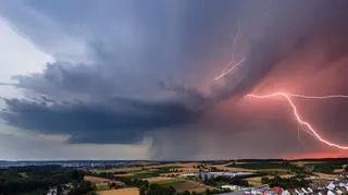 Burzowe chmury i piorun nad spokojną okolicą