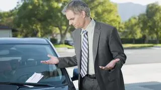 Mężczyzna znajduje mandat za wycieraczką