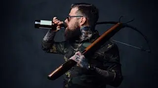 Hipster z kuszą pijący piwo rzemieślnicze