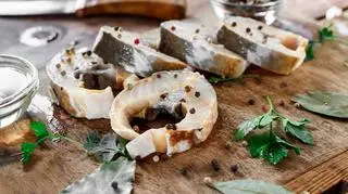 Kawałki ryby na desce do krojenia wśród liści