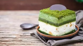 kawalek zielonego ciasta deseru na talerzu na drewniany stole