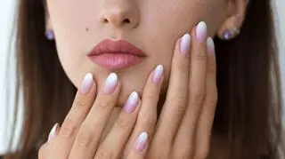 kobieta dotyka twarzy na dloniach manicure gradientowy baby boomer