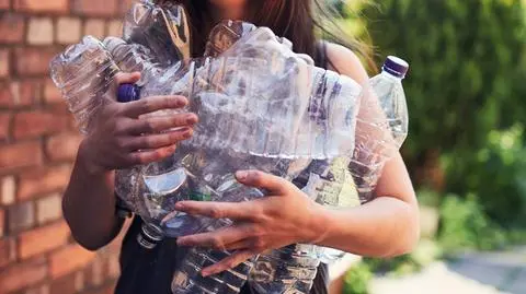 Pani niosąca plastikowe butelki 