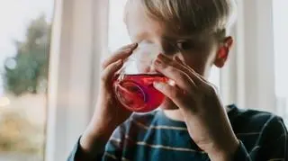 Chłopiec pijący gorący napar ze szklanki
