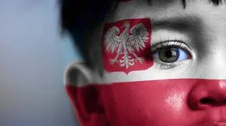 chłopiec z flagą i godłem na twarzy