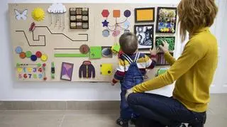 Małe dziecko z mamą bawi się tablicą manipulacyjną, jak zrobić tablicę manipulacyjną w domu