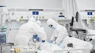 Lekarze podający tlen osobie chorej na COVID-19