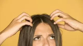 Kobieta dotyka włosów u nasady głowy