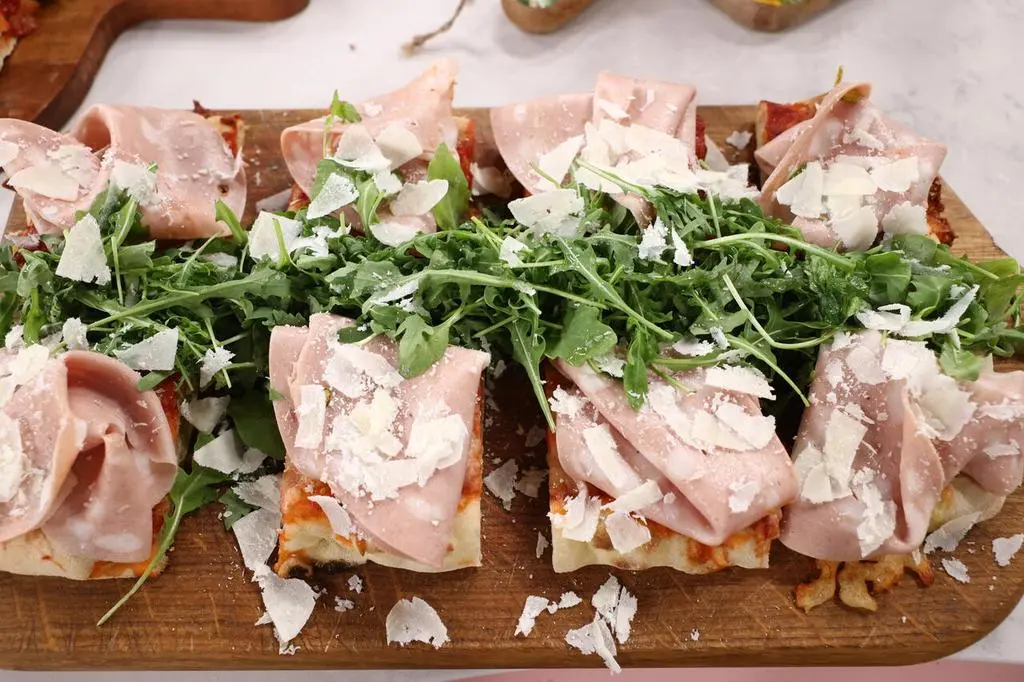 Lekka pinsa z sosem pomidorowym, mozzarellą, mortadelą pistacchio i parmezanem