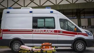 Ambulans, przed nim ratownicze nosze.