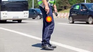 Policjant z tarczą do kierowania ruchem. Radar Fotorapid Pro mierzący dystans pomiędzy pojazdami
