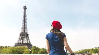 kobieta stoi na tle Wieży Eiffla we Francji