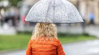 Kobieta pod parasolką w deszczowy wiosenny dzień