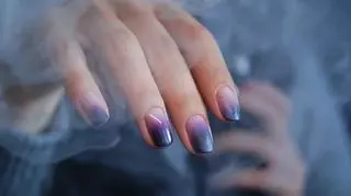 Kobieca dłoń z efektownie pomalowanymi paznokciami. Smoke nails. Manicure na jesień.