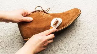 osoba, która czyści zamszowe buty 