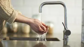 kobieta myje ręce pod bieżącą wodą z kranu