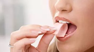 Kobieta, która wkłada do ust gumę do żucia 