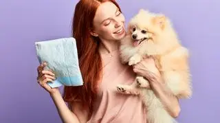 Kobieta trzymająca psa i pieluchę. Pieluchy dla psów. Zwierzęta domowe. Akcesoria dla zwierząt.