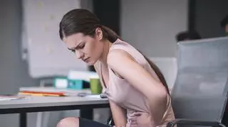 Kobieta z bólem brzucha w pracy
