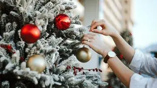 Kobieta wiesza bombkę na choince