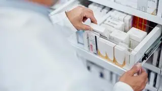 Aptekarzy wyjmujący leki z szuflady