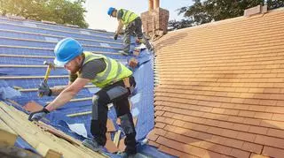 Robotnicy na dachu domu.