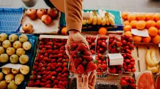 Osoba kupująca truskawki na bazaru