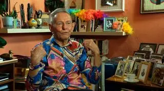 Ma 84 lata, jest synem wojskowego i do dziś występuje na scenie jako drag queen