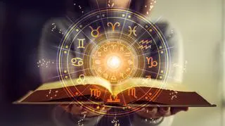 Kobieta trzyma książkę astrologiczną