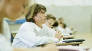 Nastolatek na egzaminie zastanawia się nad odpowiedzią.
