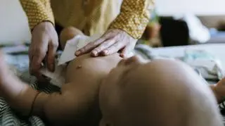 dziecko, które ma zmienianą pieluchę