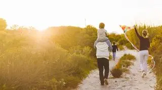 wakacje 2022, rodzina z dziećmi biegnie na plaży