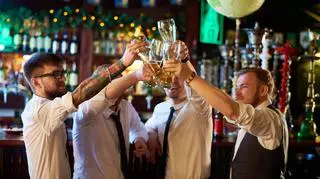 Mężczyźni w barze podnoszą toast