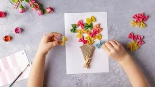 dziecko robi luarkę na dzień matki z makaronu