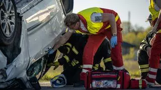 Ratownik medyczny i strażak na miejscu wypadku samochodowego. 