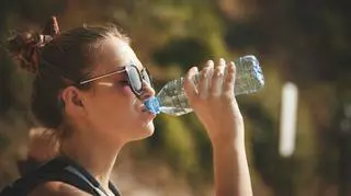 kobieta pije wodę z butelki