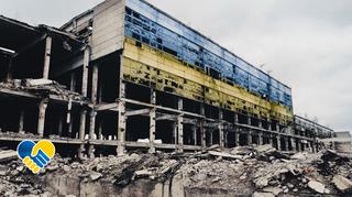 Ukrainka pokazuje zniszczenia budynków mieszkalnych w Irpieniu